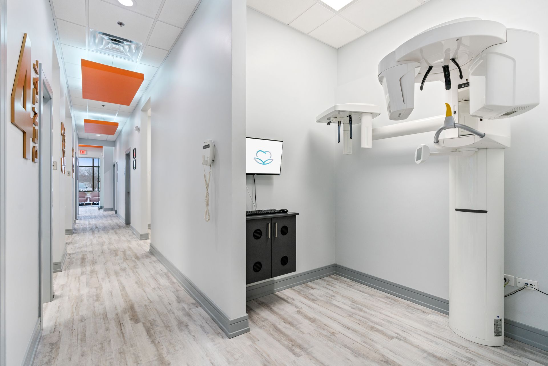 A dental office with a large x-ray machine in the middle of the hallway.