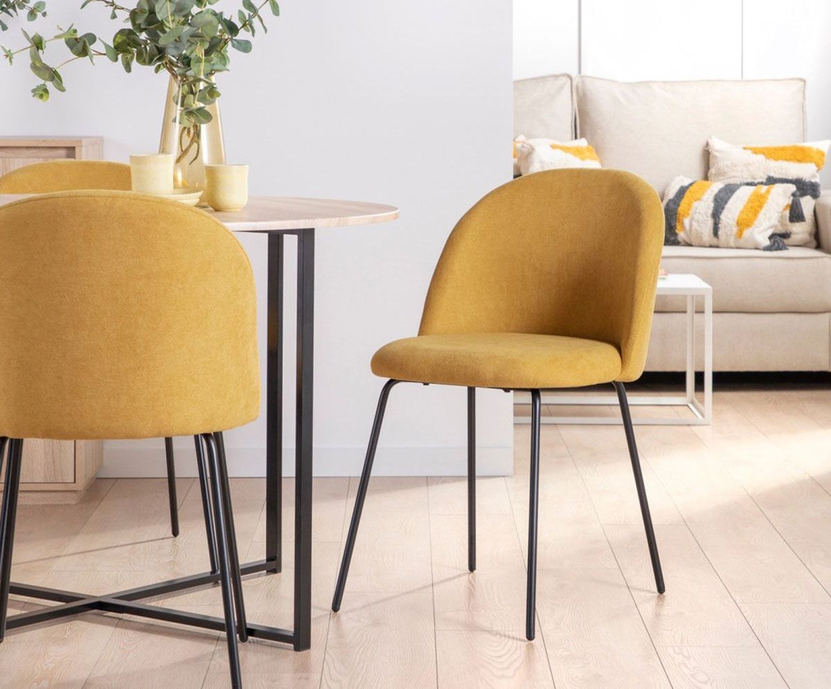dos sillas amarillas están sentadas alrededor de una mesa en un comedor