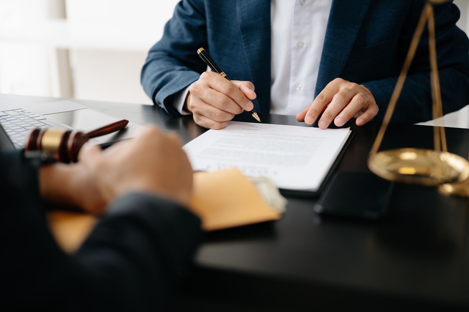 A man is sitting at a table signing a document.