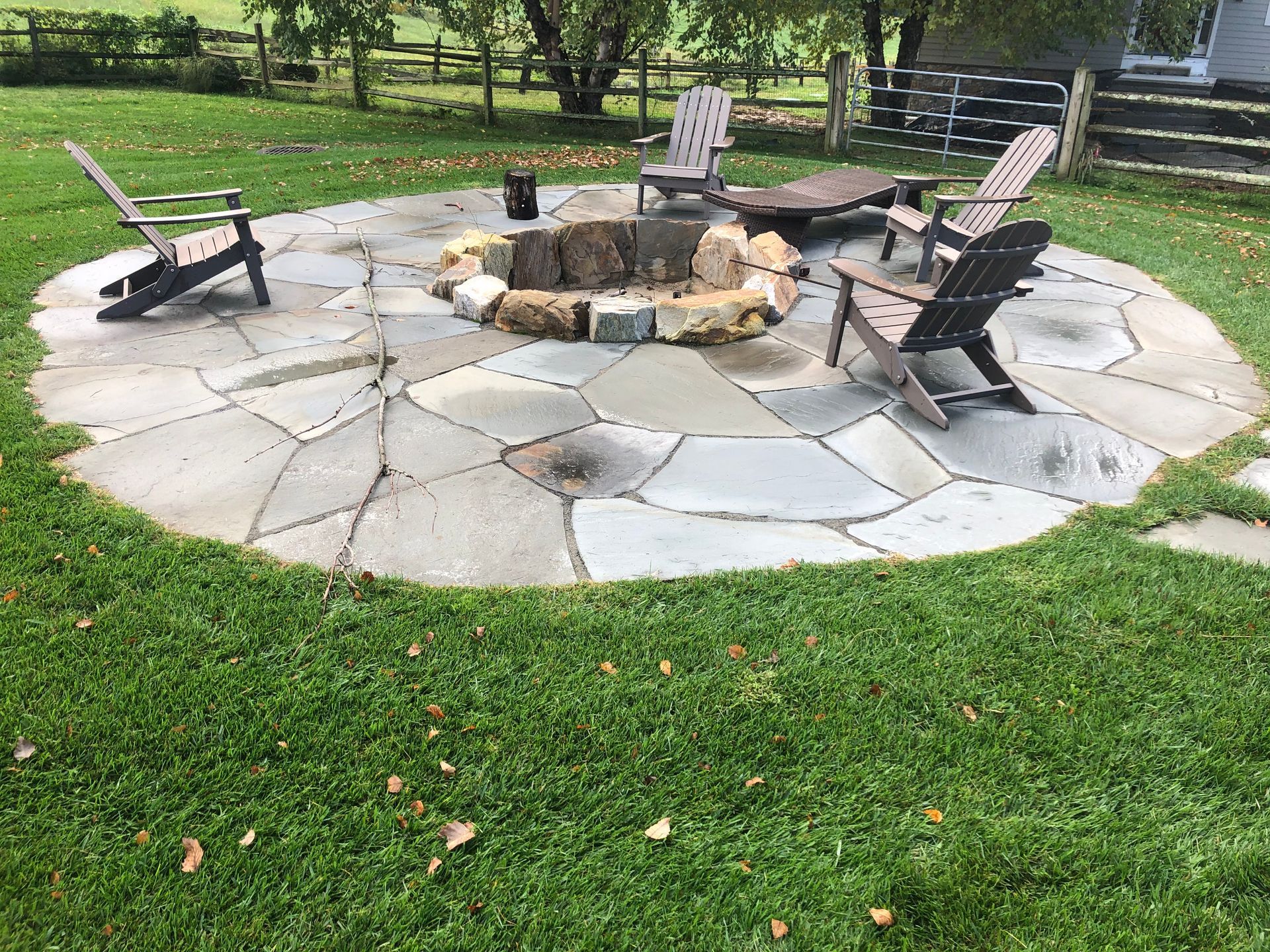A Stone Patio with Chairs Around a Fire Pit — Kennett Square, PA — Classic Lawns