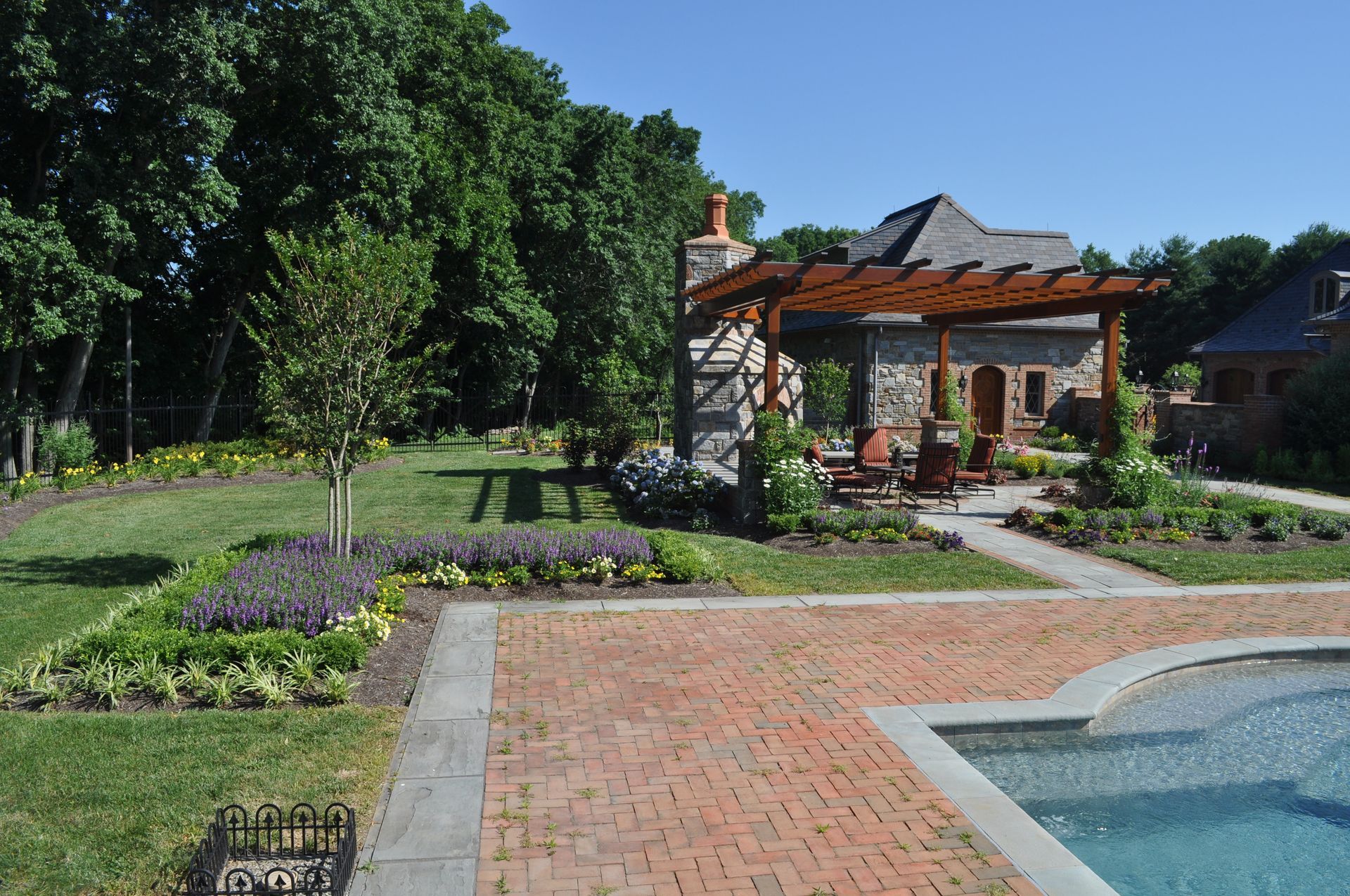 A Stone Patio with a Stone Building and a Statue — Kennett Square, PA — Classic Lawns