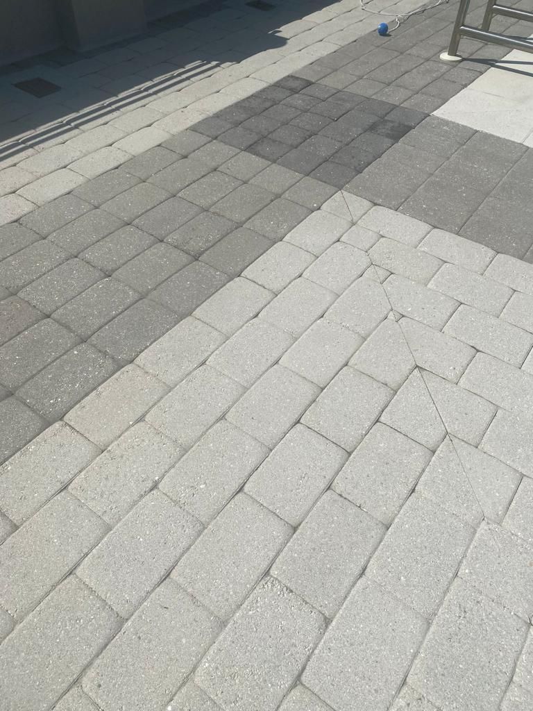 Light-colored brick pavers arranged in a diagonal pattern, transitioning to darker gray squares.