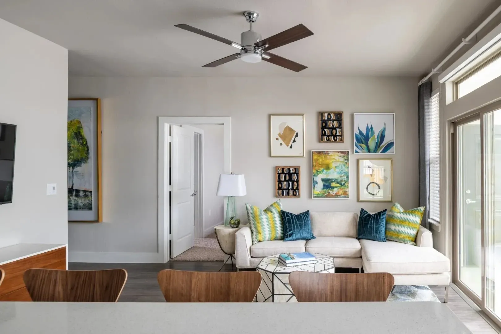 Brightly decorated living room with a sofa, artwork on the walls, and a coffee table.