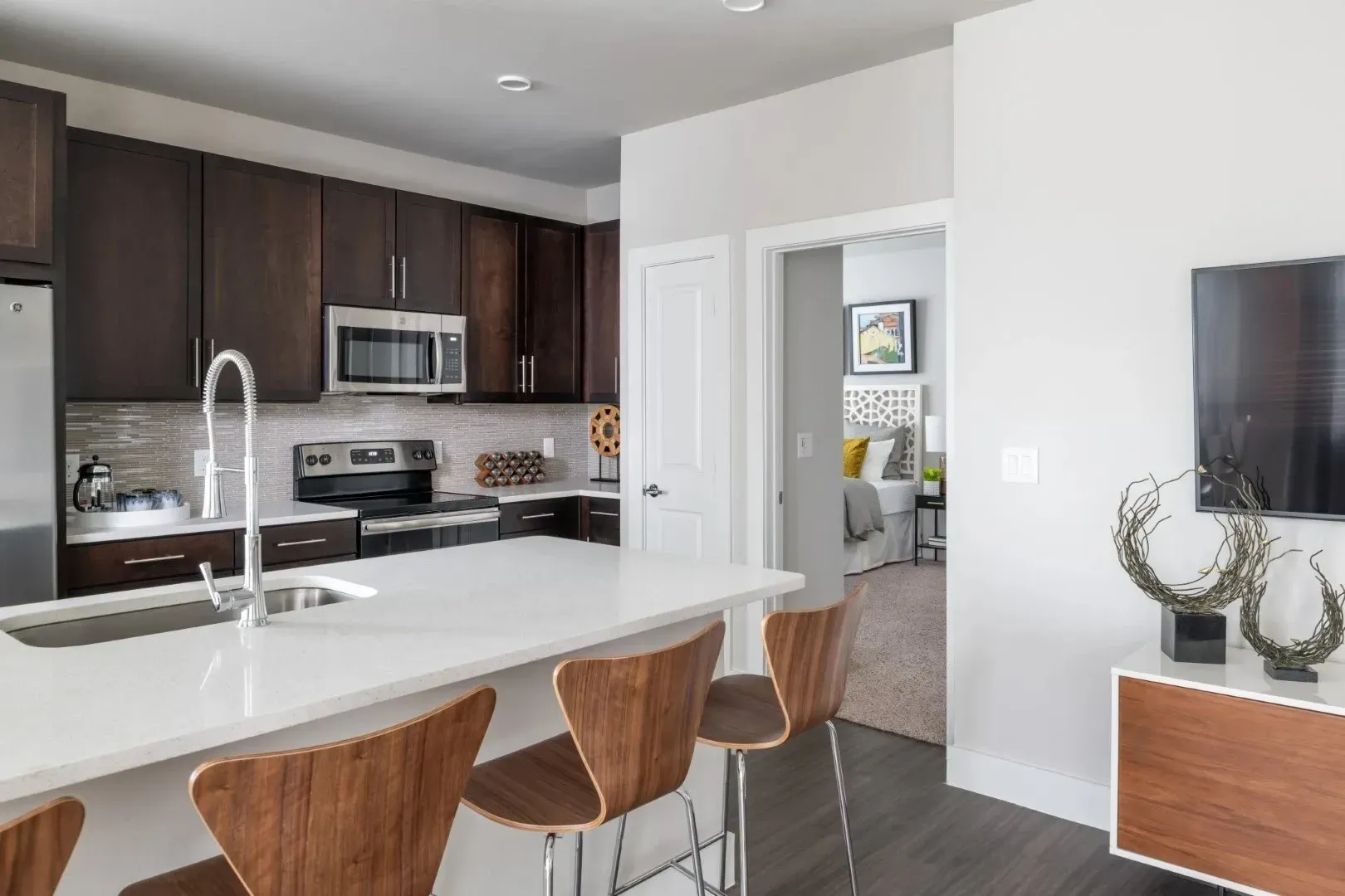 Modern kitchen with stainless steel appliances and a view into the living area
