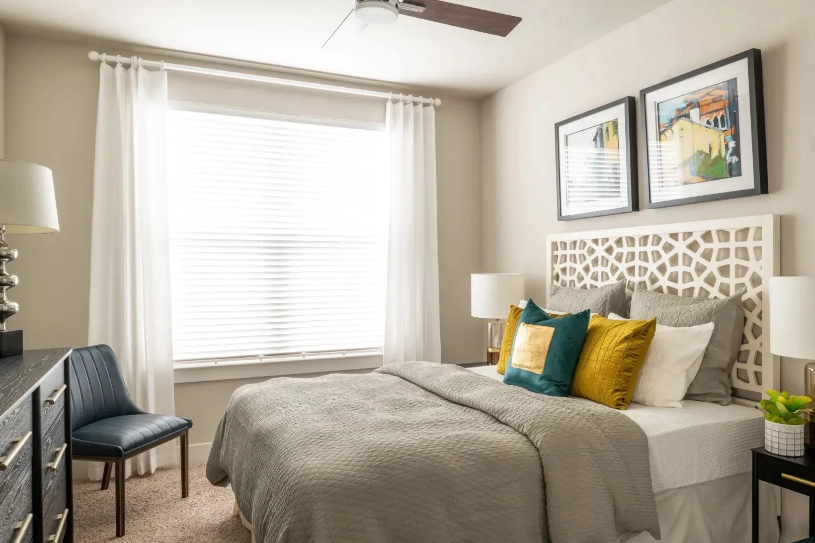 Stylish bedroom with decorative pillows and bedside lighting