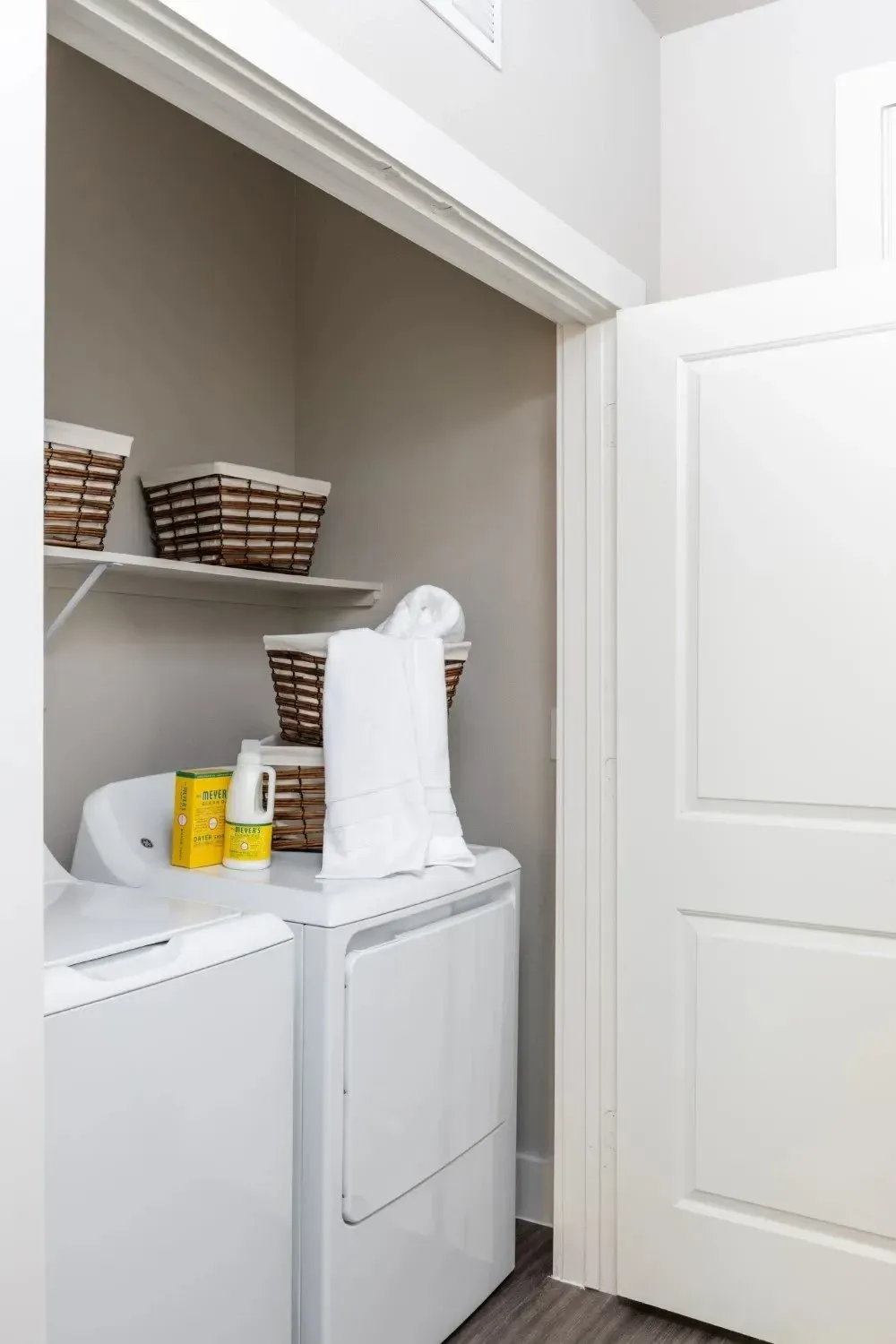 Laundry area featuring a washing machine and dryer with baskets and towels