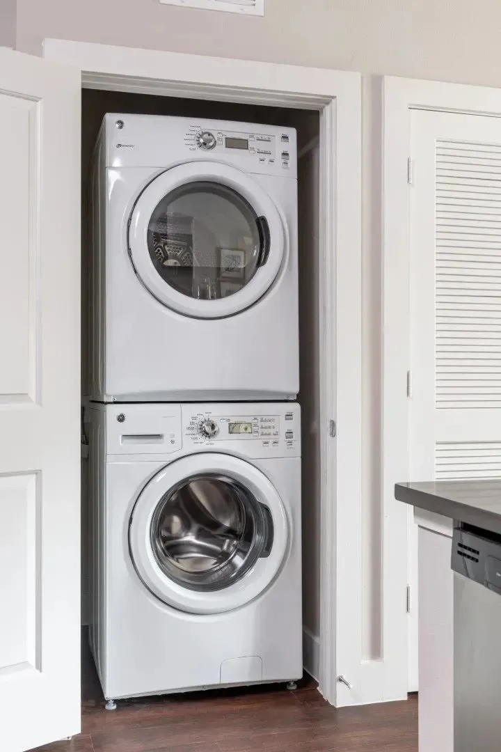 Washer and dryer stacked in a hallway closet