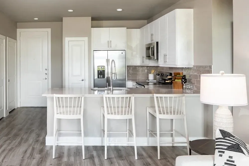 Modern kitchen with white cabinets and bar stools