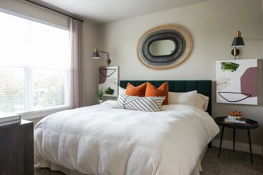 Stylish bedroom featuring a green velvet headboard and decorative pillows