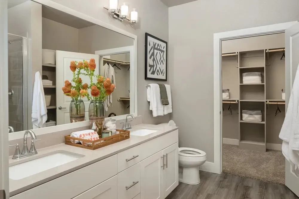 Spacious apartment bathroom with dual sinks and modern design.