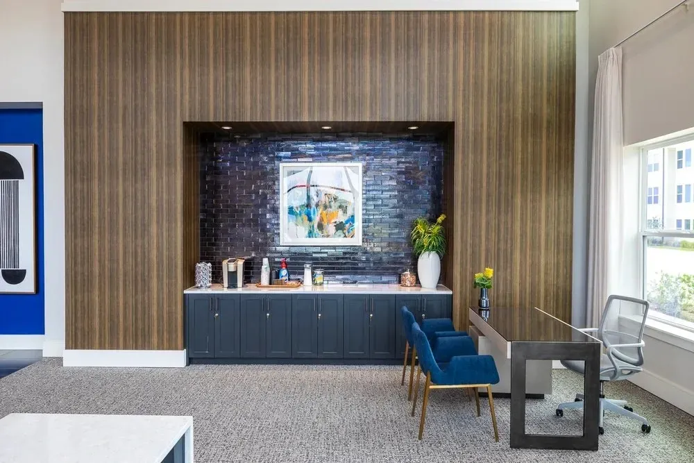 Interior view of a stylish community lounge with cabinets and artwork