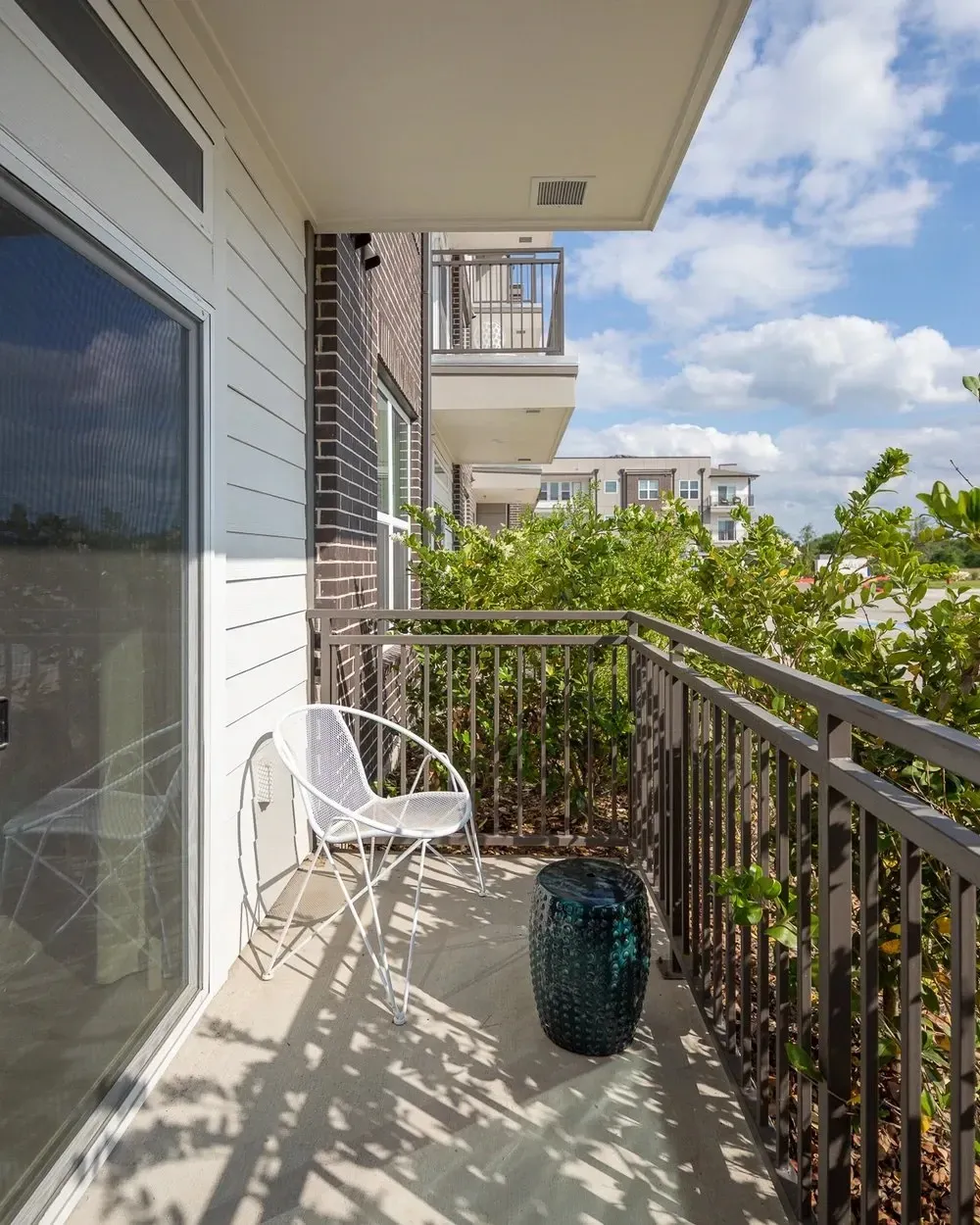 Balcony view with a white chair and a decorative blue table