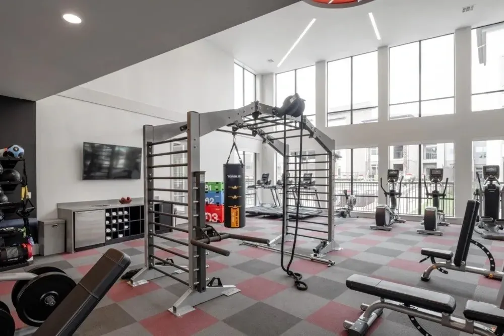 Modern fitness center with exercise equipment and large windows