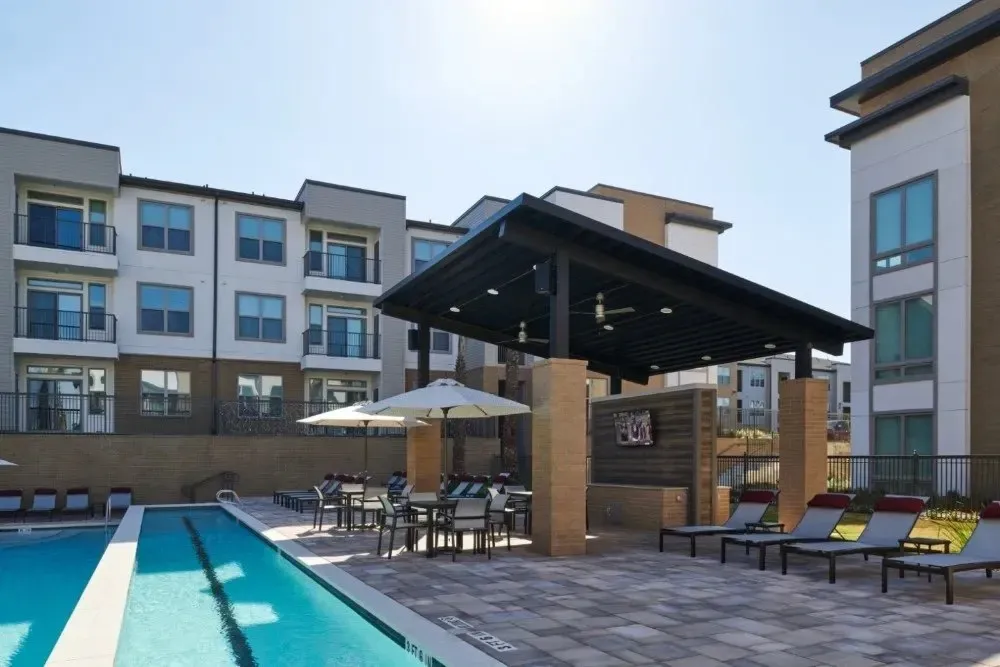 Swimming pool area with lounge chairs and a shaded seating area