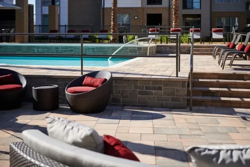 Outdoor pool area with seating and lounge chairs