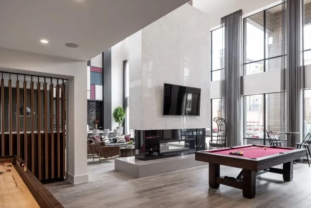 Stylish communal lounge with pool table and large windows.
