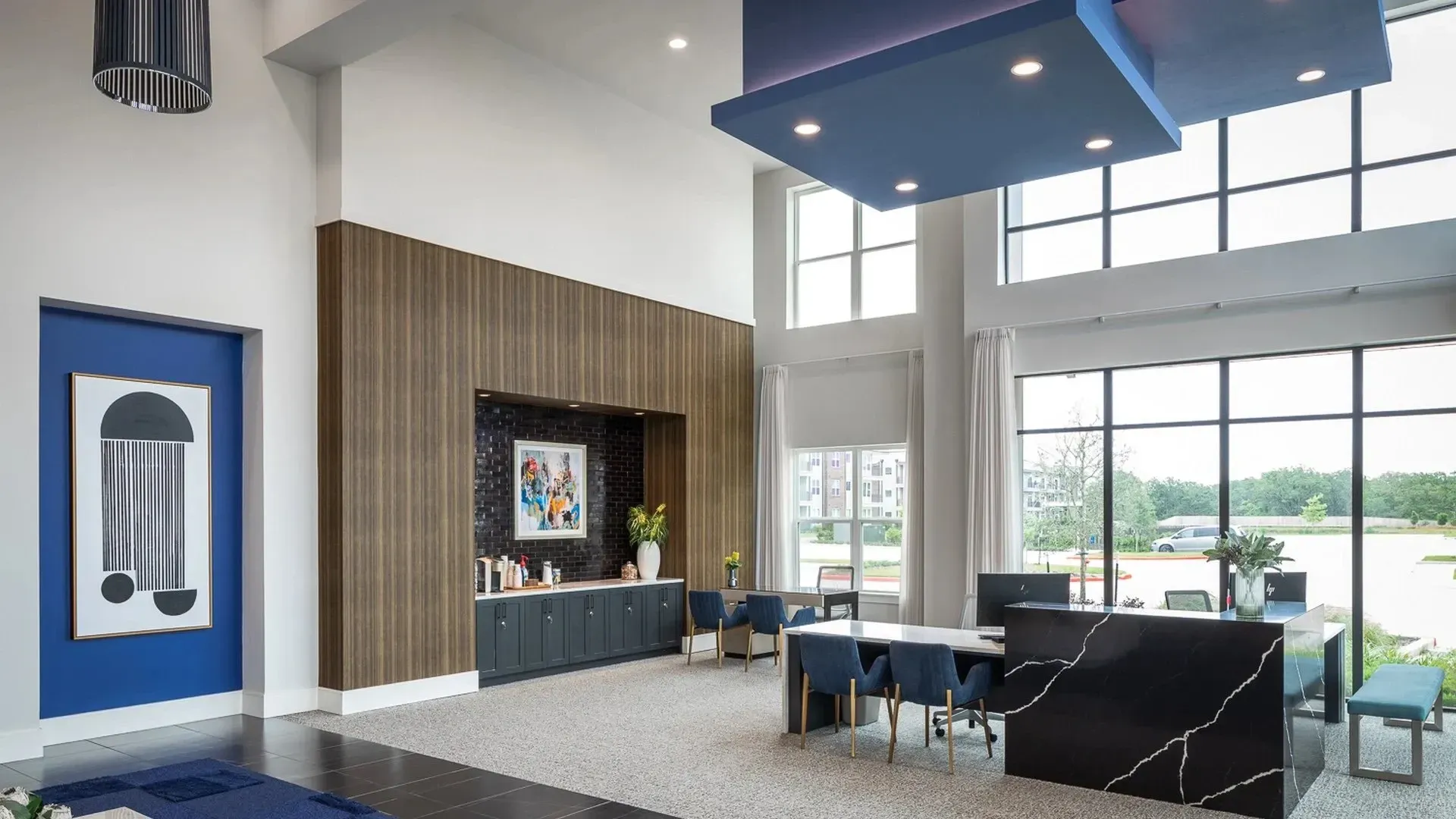 Modern community lounge area with large windows and contemporary decor.