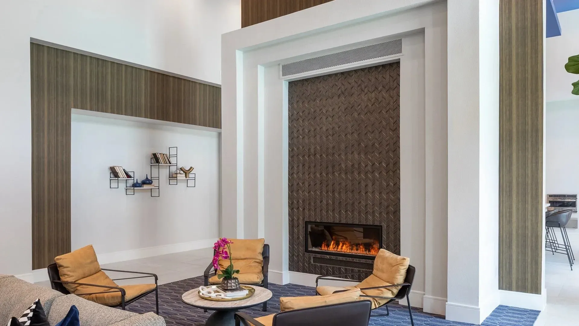 Modern community lounge with a fireplace and seating area