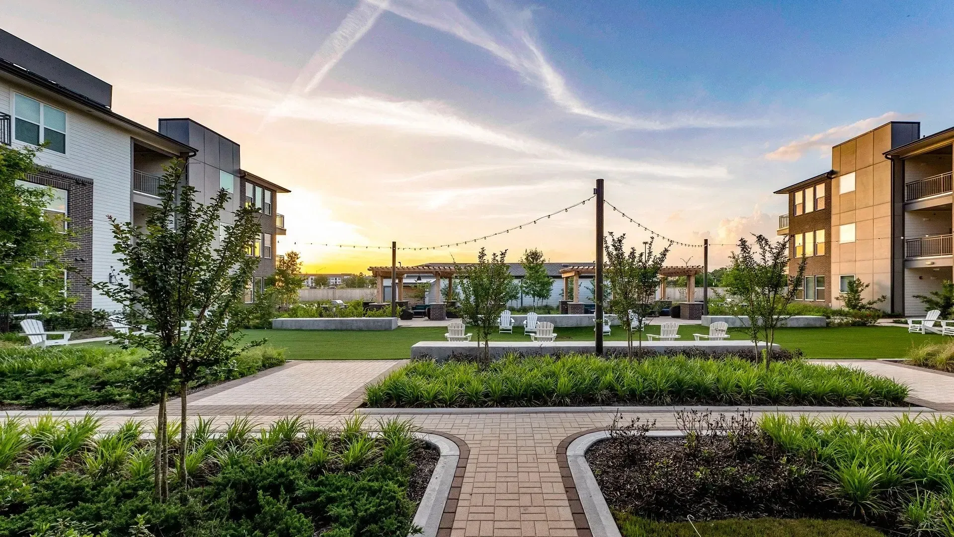 Beautiful landscaped community area with seating and sunset view.