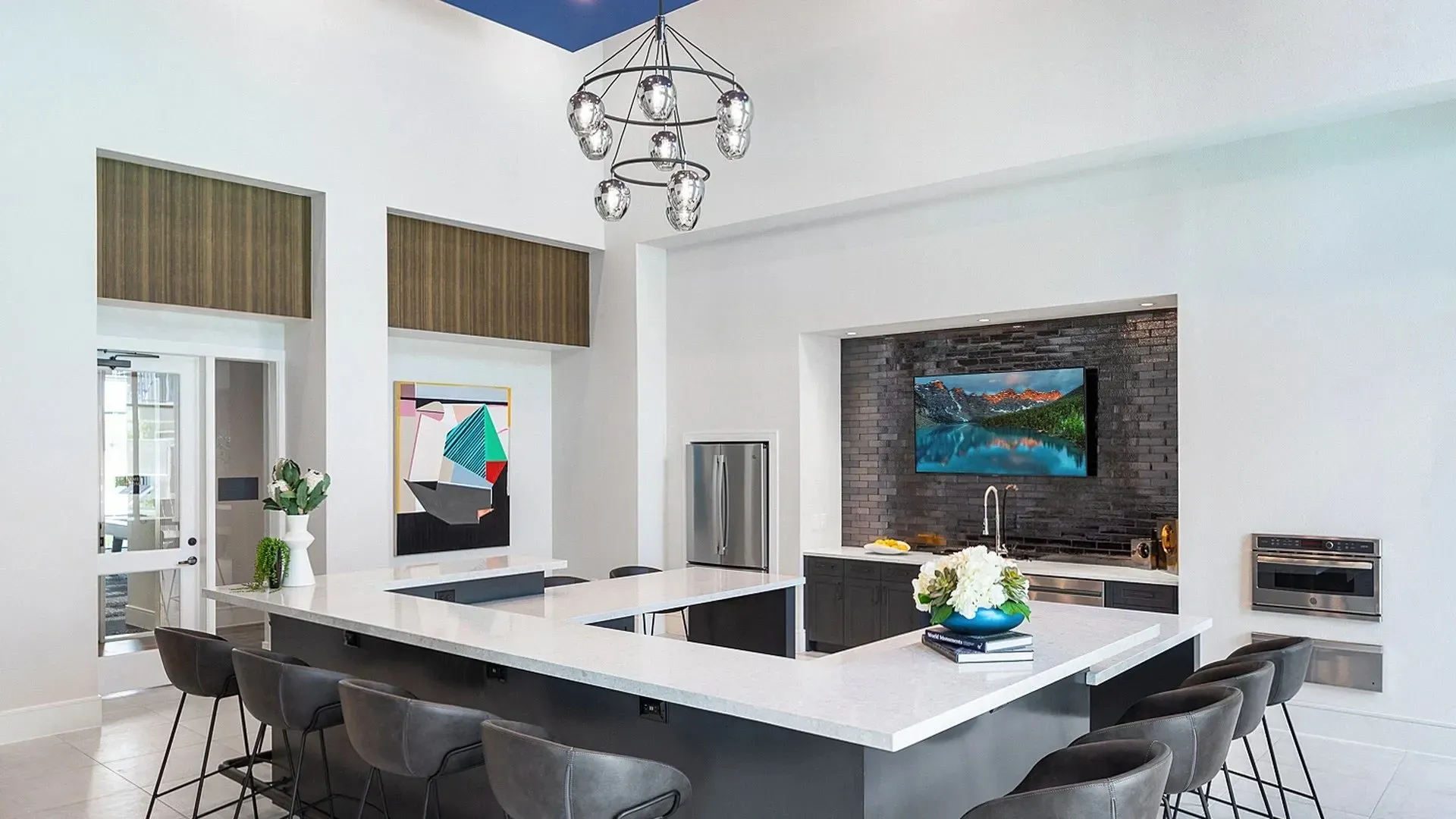 Modern community lounge with a large kitchen island and stylish decor.