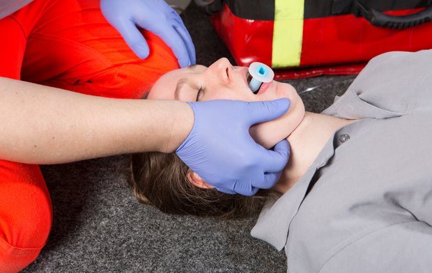 A person is laying on the floor with a tube in their mouth.