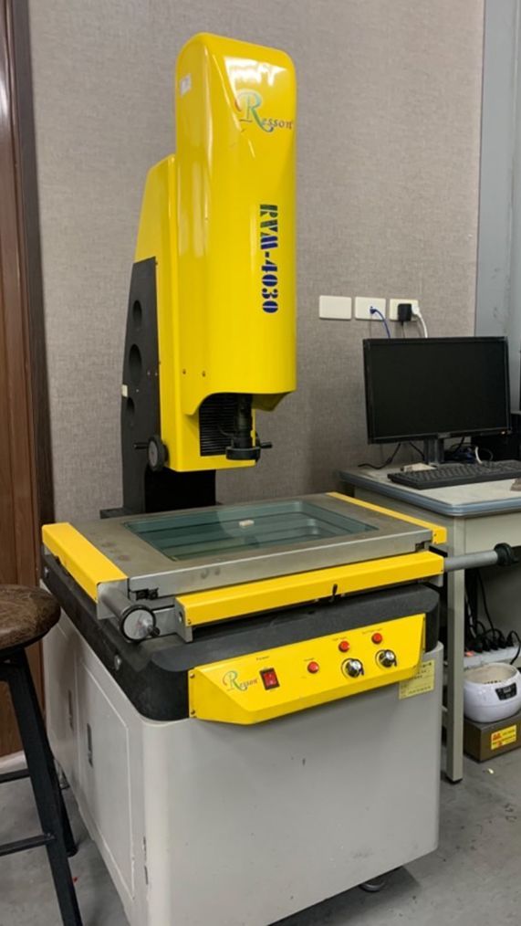 房間裡有一台黃色機器，旁邊有一台電腦。