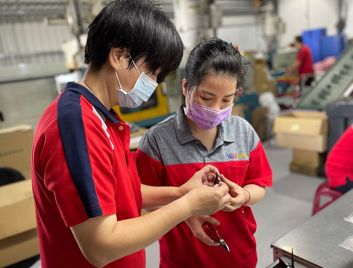 一男一女戴著口罩在一家工廠工作。