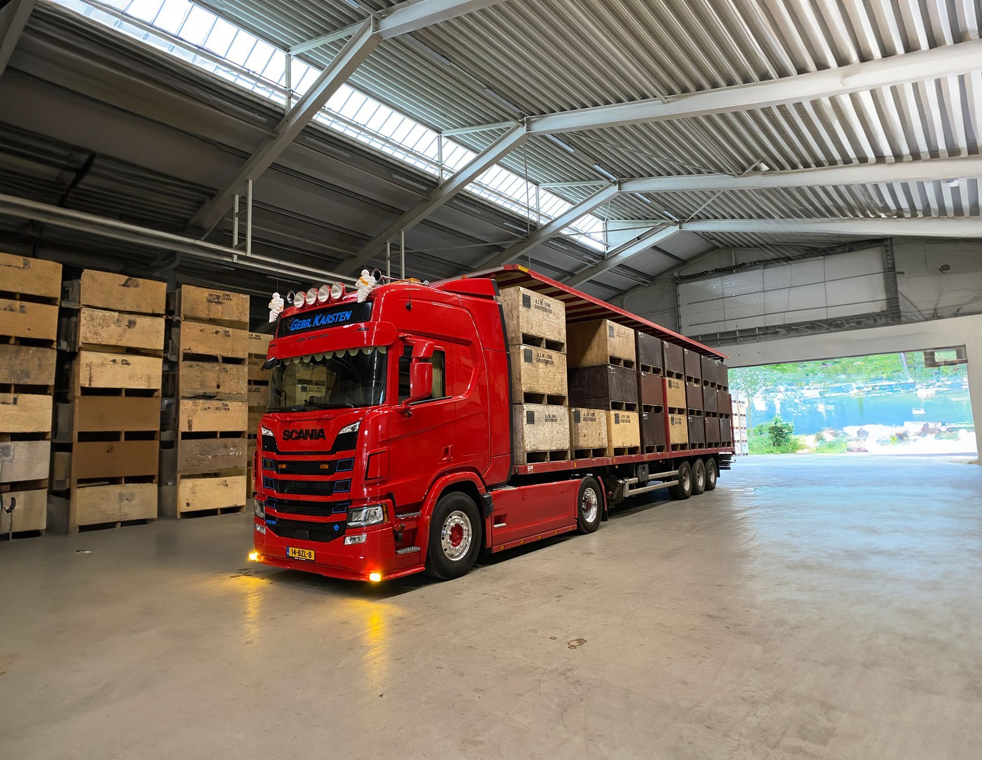 Rode vrachtwagen geladen met houten kratten in een loods.