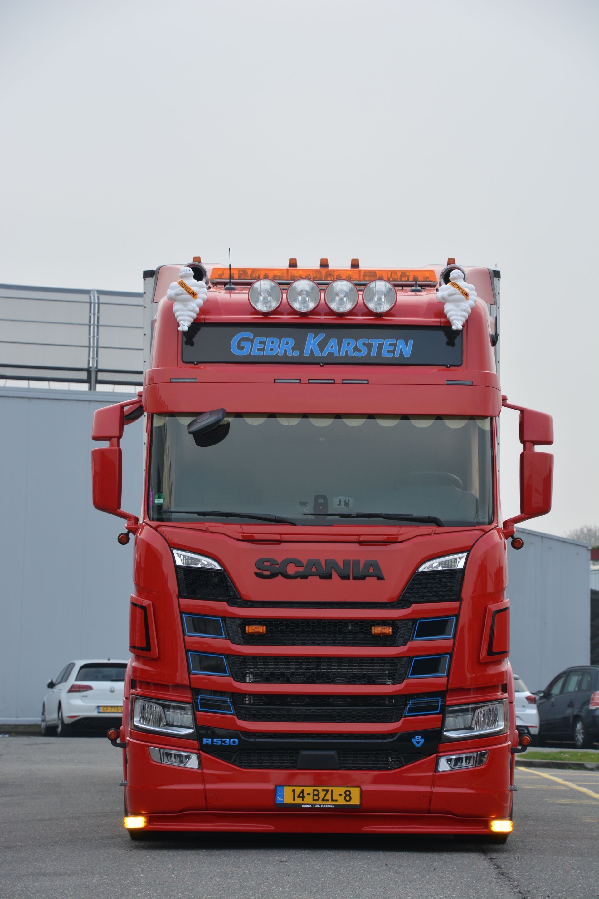 Rode Scania vrachtwagen met verlichting en de naam 