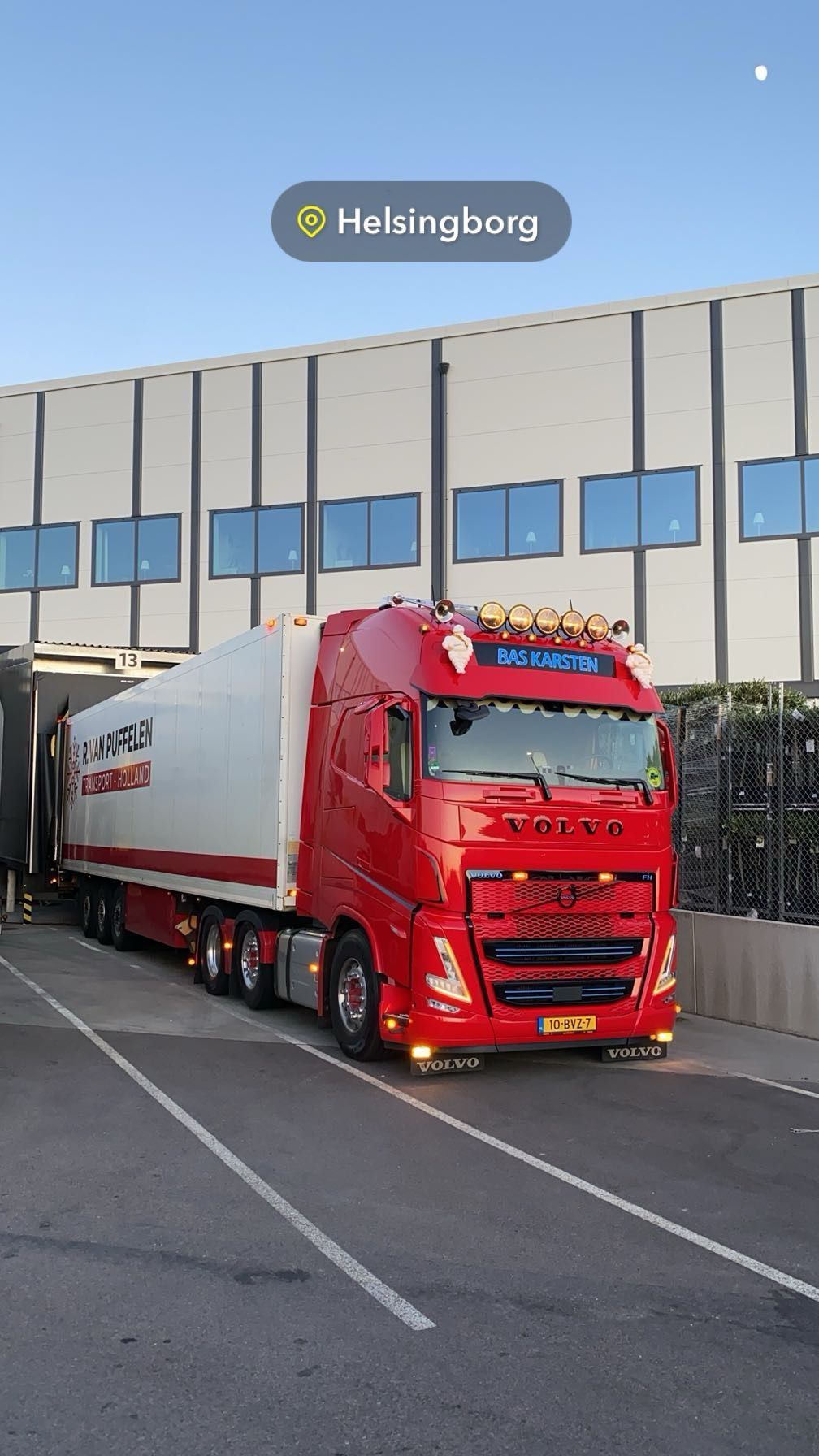 Rode vrachtwagen met witte oplegger geparkeerd bij een laadperron in Haderslev.