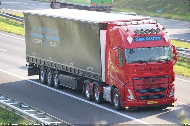 Rode Volvo vrachtwagen met oplegger op de snelweg. 