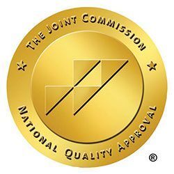 The Joint Commission National Quality Approval seal, gold color with logo.