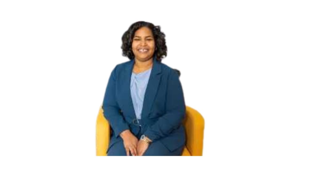 A woman in a suit sitting in a chair smiling