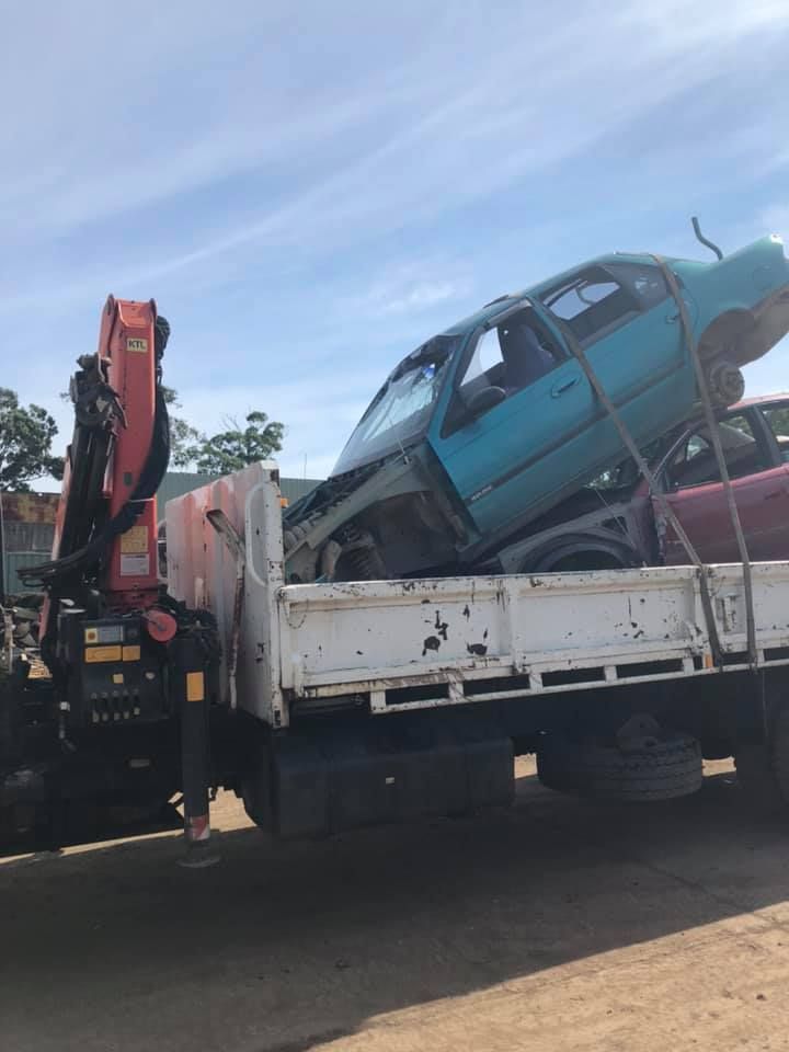 A Truck With A Crane Is Carrying A Blue And Red Car — RiverCity Recyclers In Taree, NSW