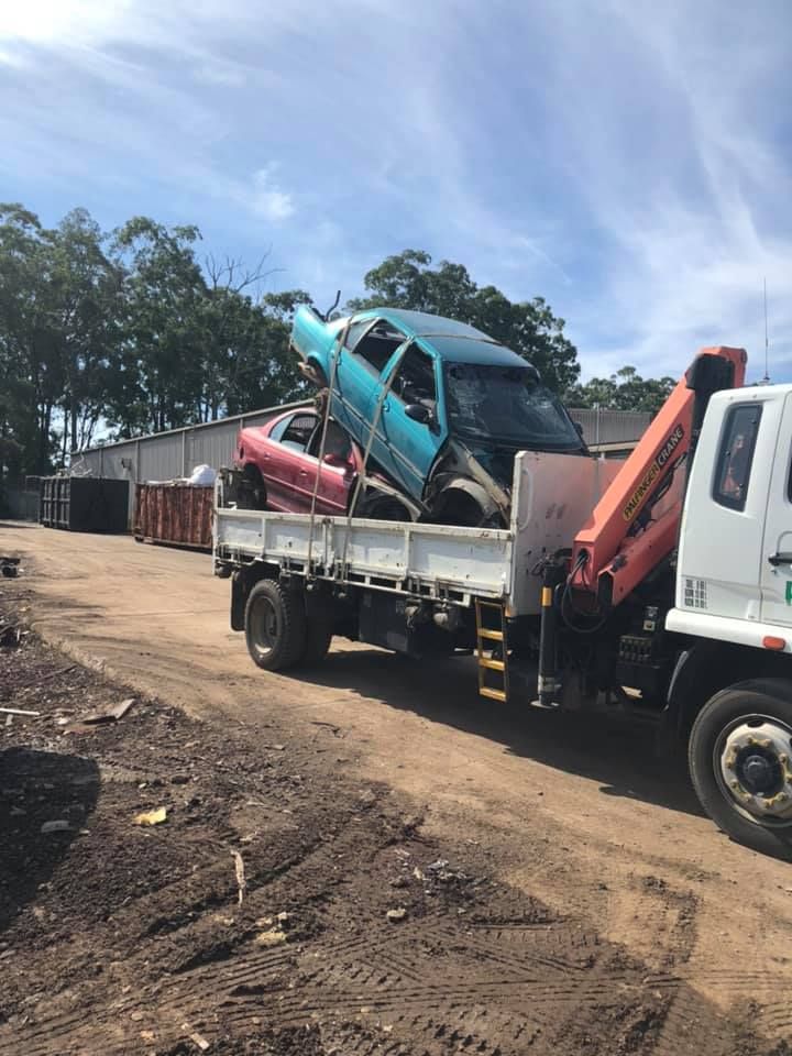 A Tow Truck Is Carrying A Pink Car And A Blue Car — RiverCity Recyclers In Forster, NSW