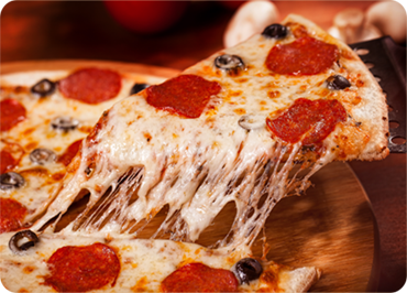 A slice of pepperoni pizza is being taken out of a pizza on a cutting board.