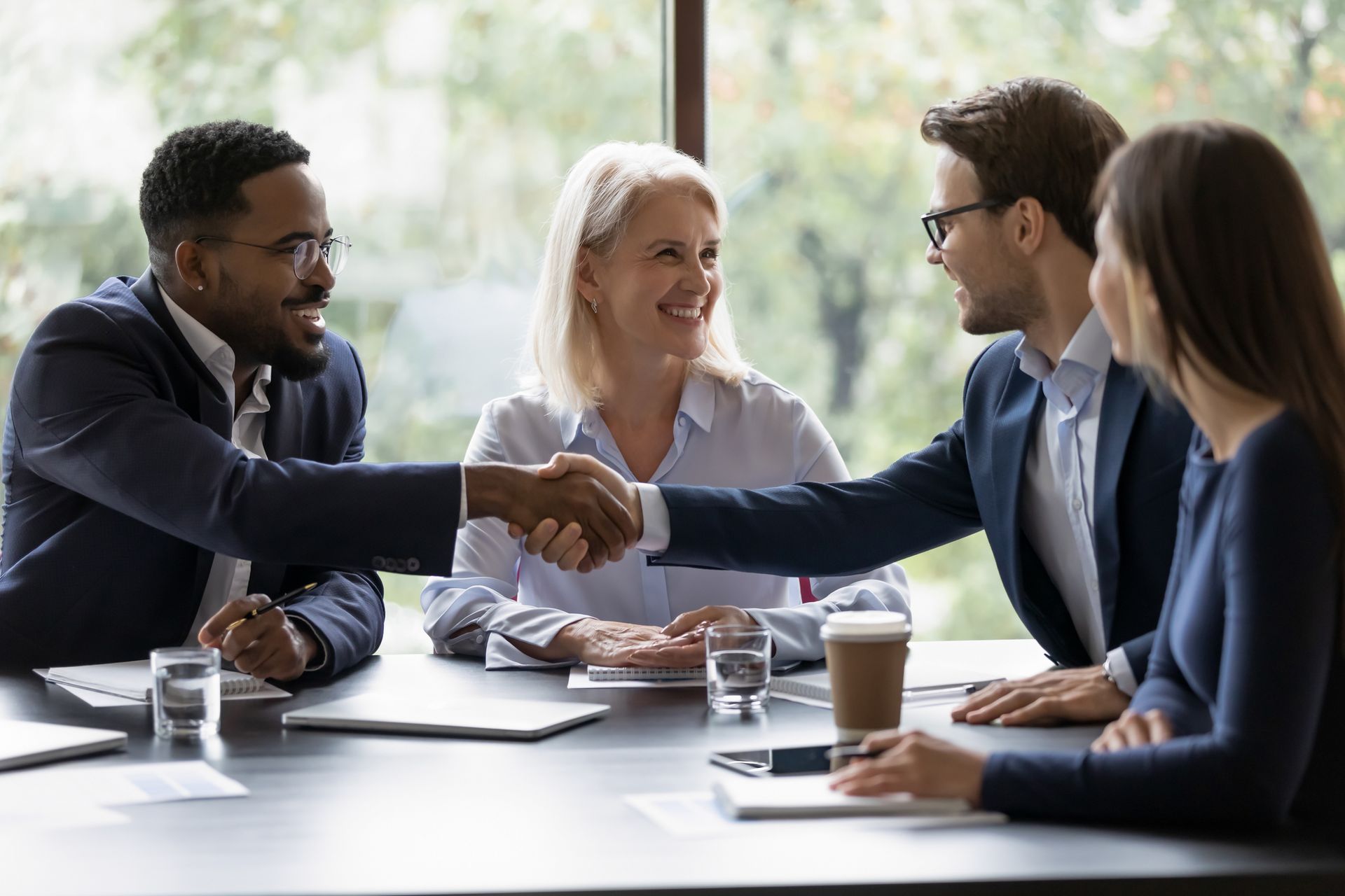 A group of people are shaking hands at a table.