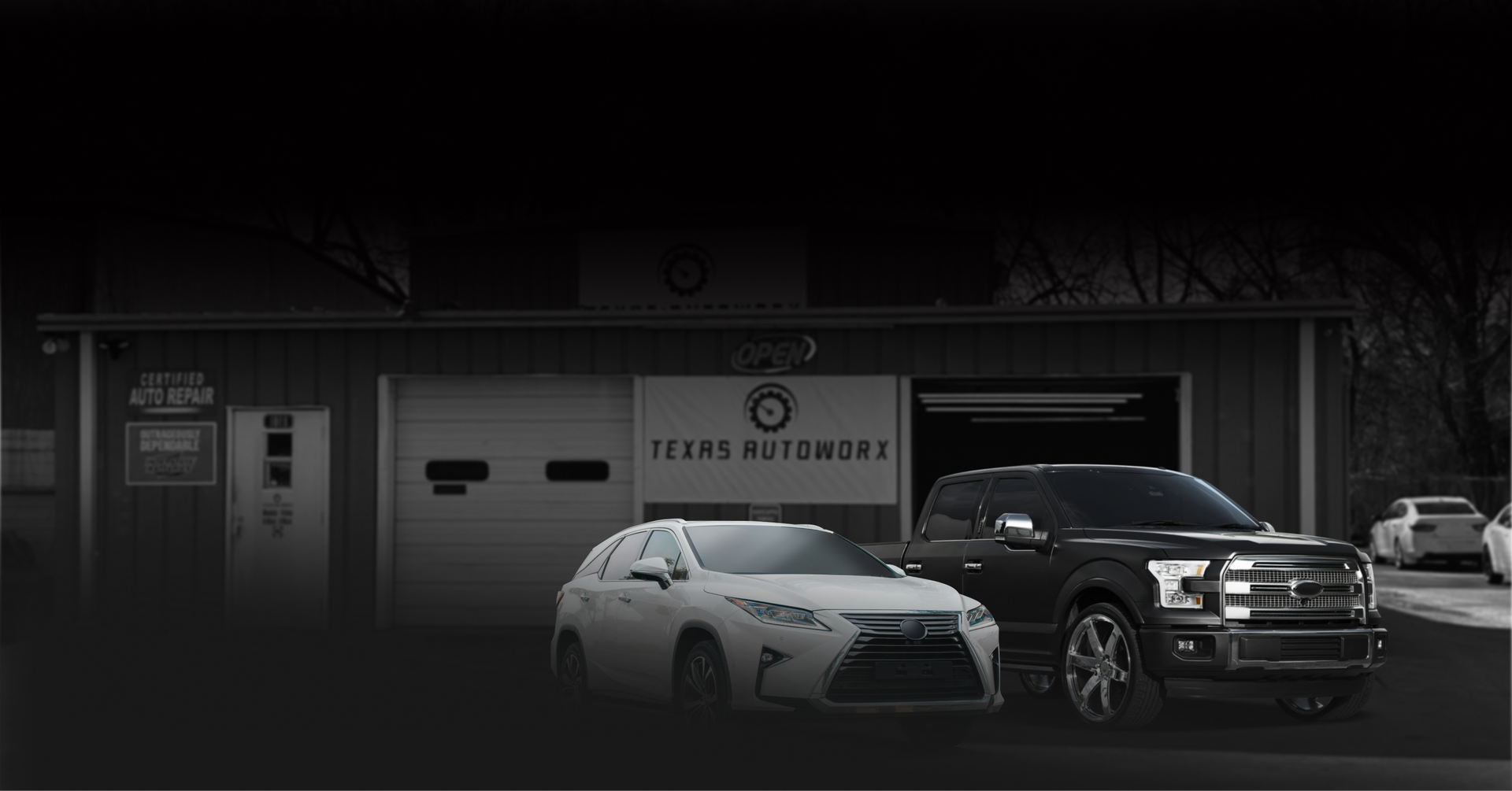 White sedan and black pickup parked outside a  service | Texas Autoworx