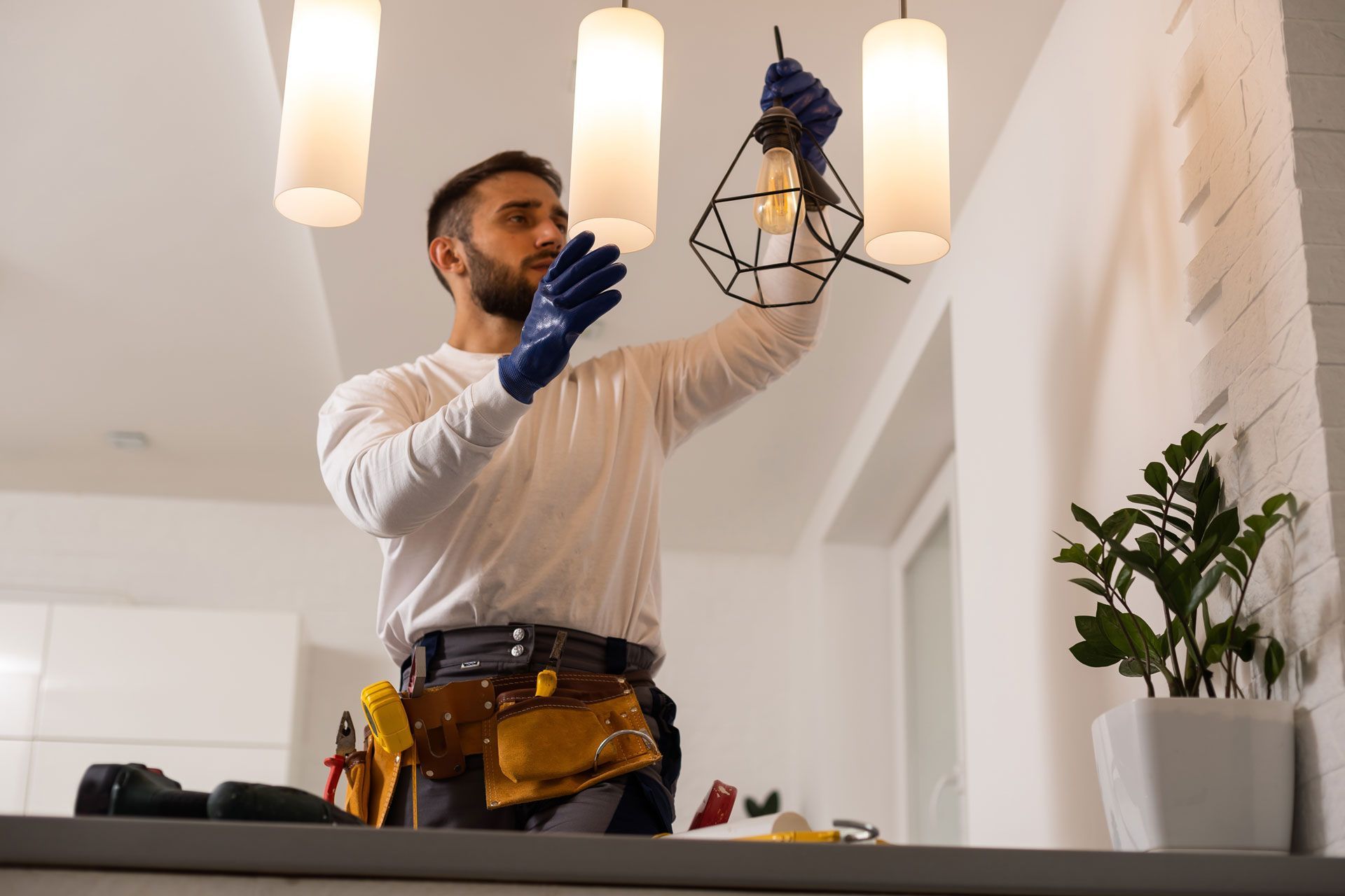 a man is fixing a light fixture in a living room