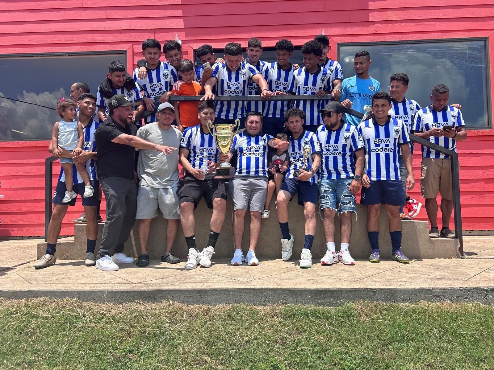 Baseball glove with ball on green grass, with blurred baseballs in the background.