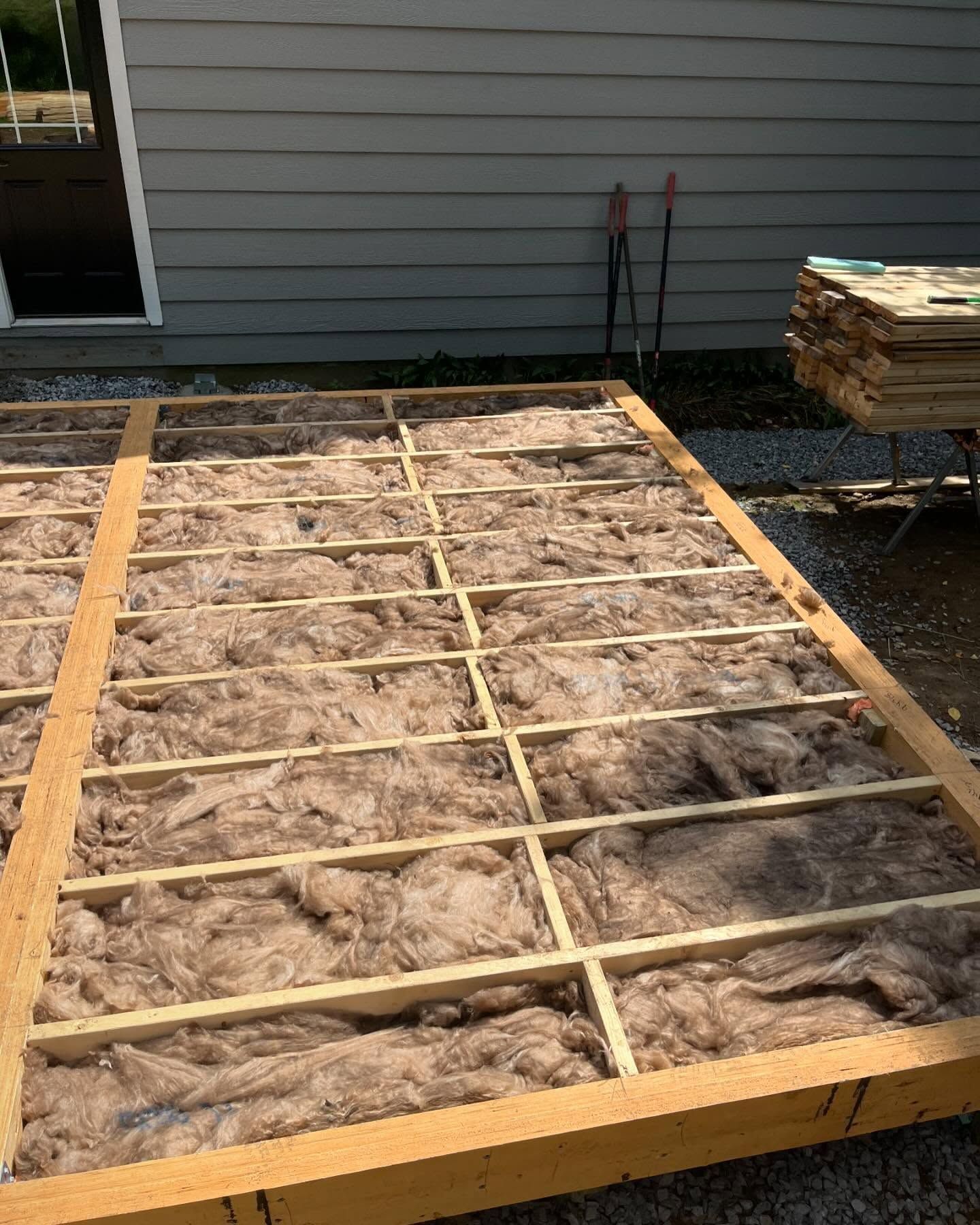 Wooden frame filled with insulation; construction site, outdoors.