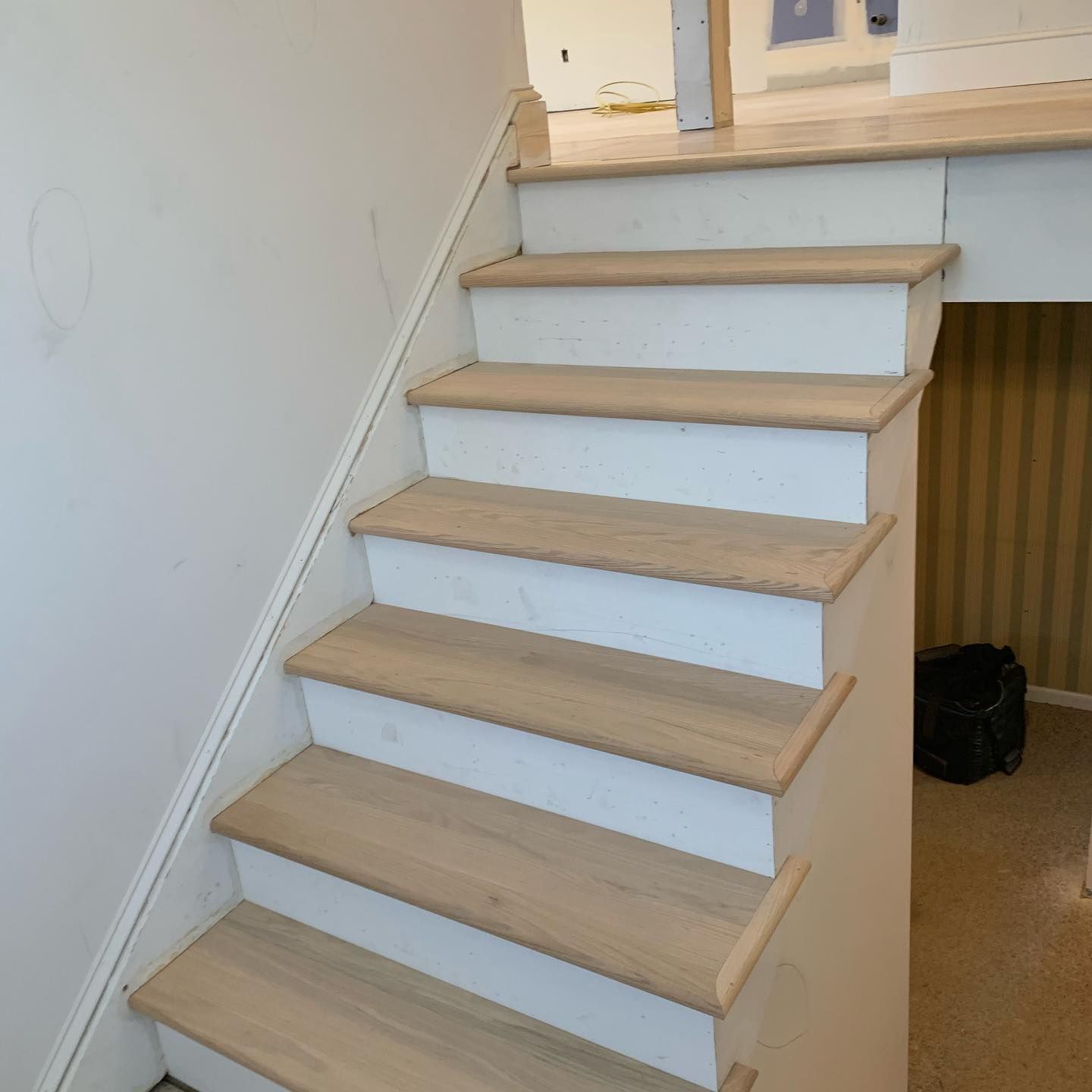 Staircase with light wood steps and white risers, leading to a landing area.