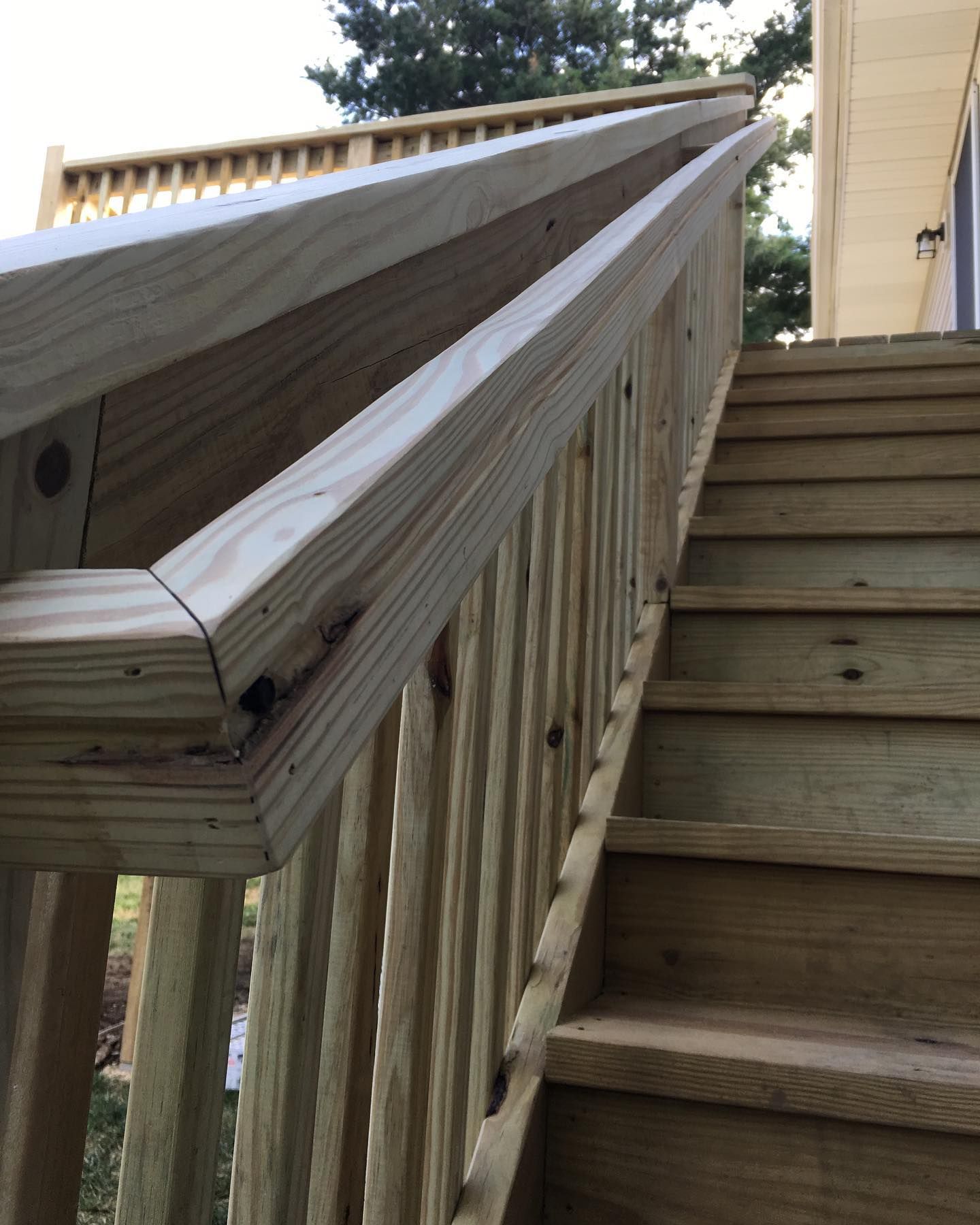 Wooden outdoor staircase with a handrail.