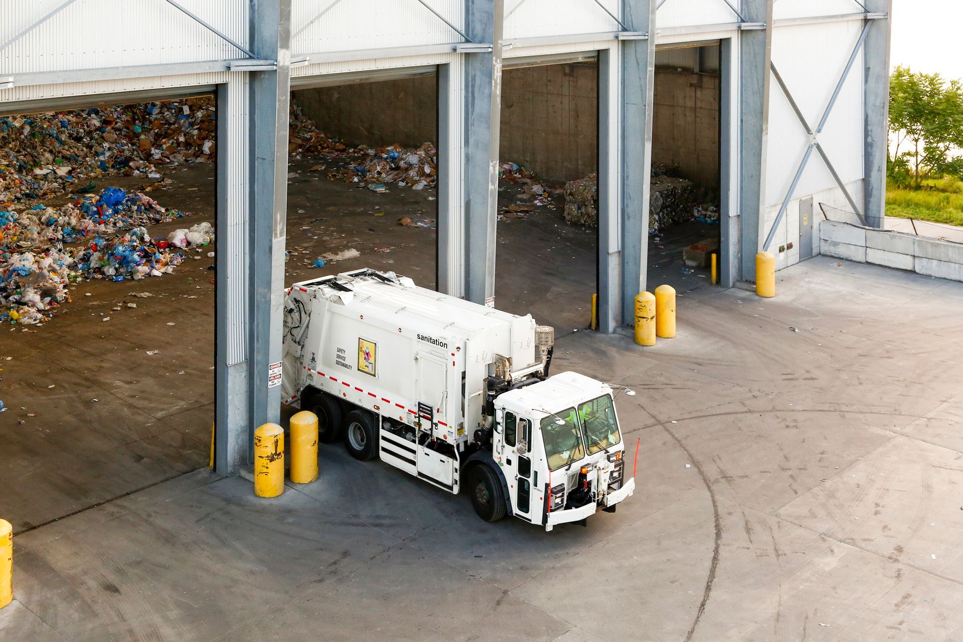 A garbage truck is parked in front of a building.