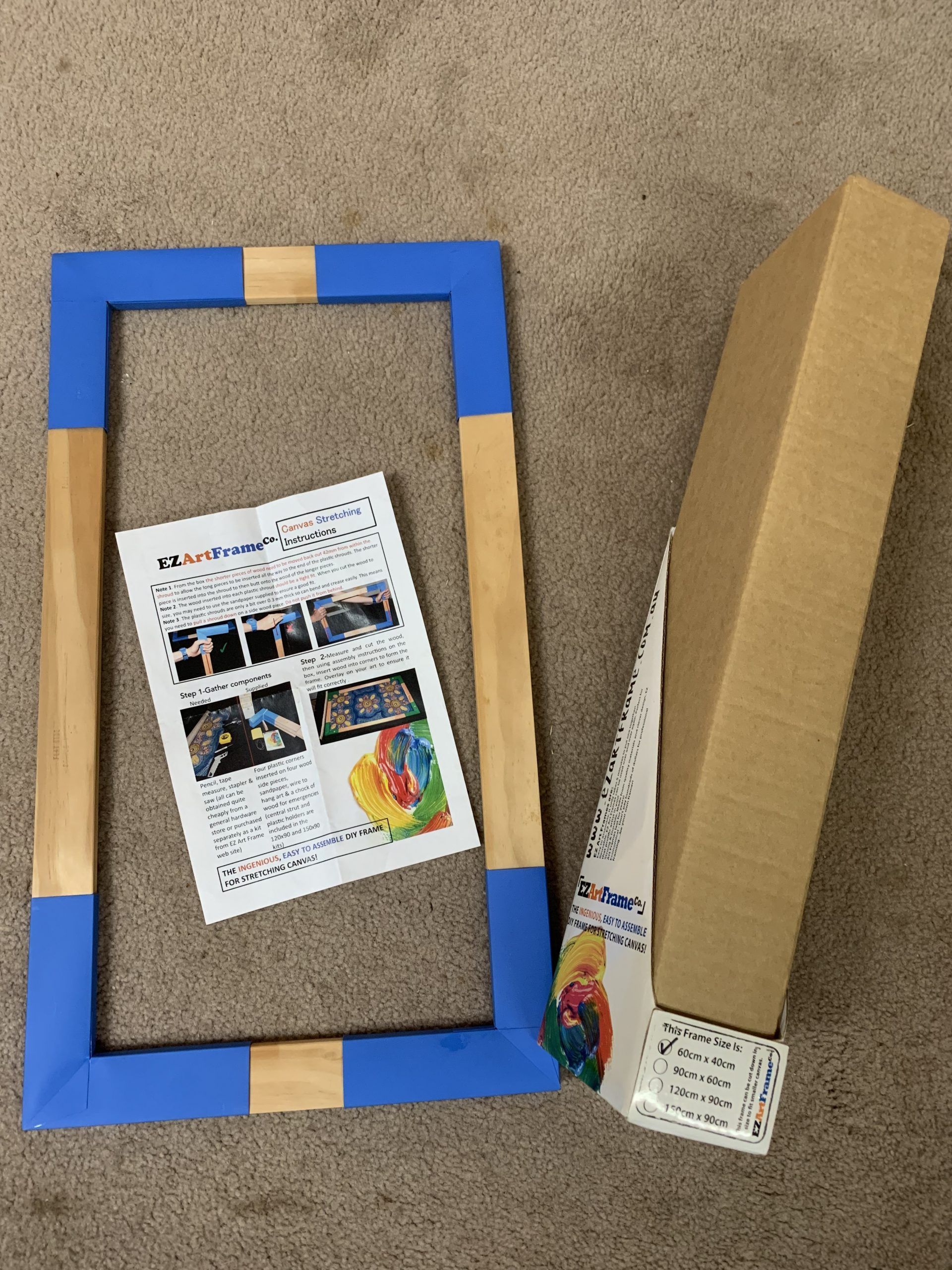 Blue and tan frame with instructions and a cardboard box, presumably for artwork.