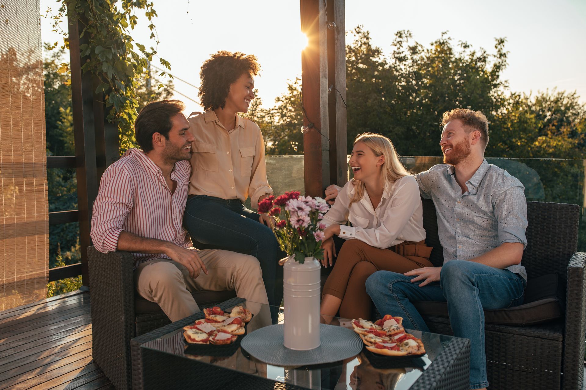 A group of people are sitting on a couch eating pizza.