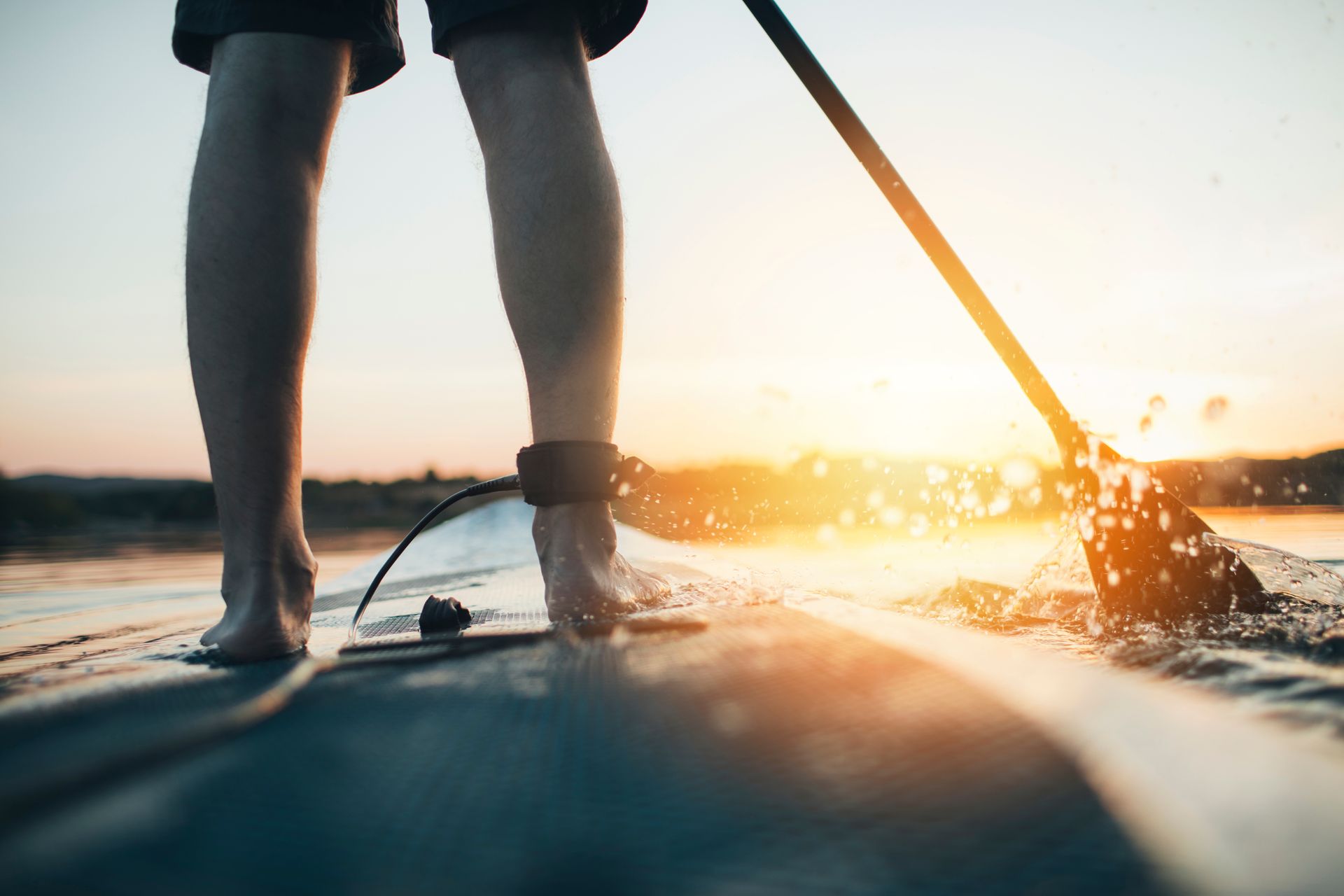 A person is standing on a paddle board in the water.