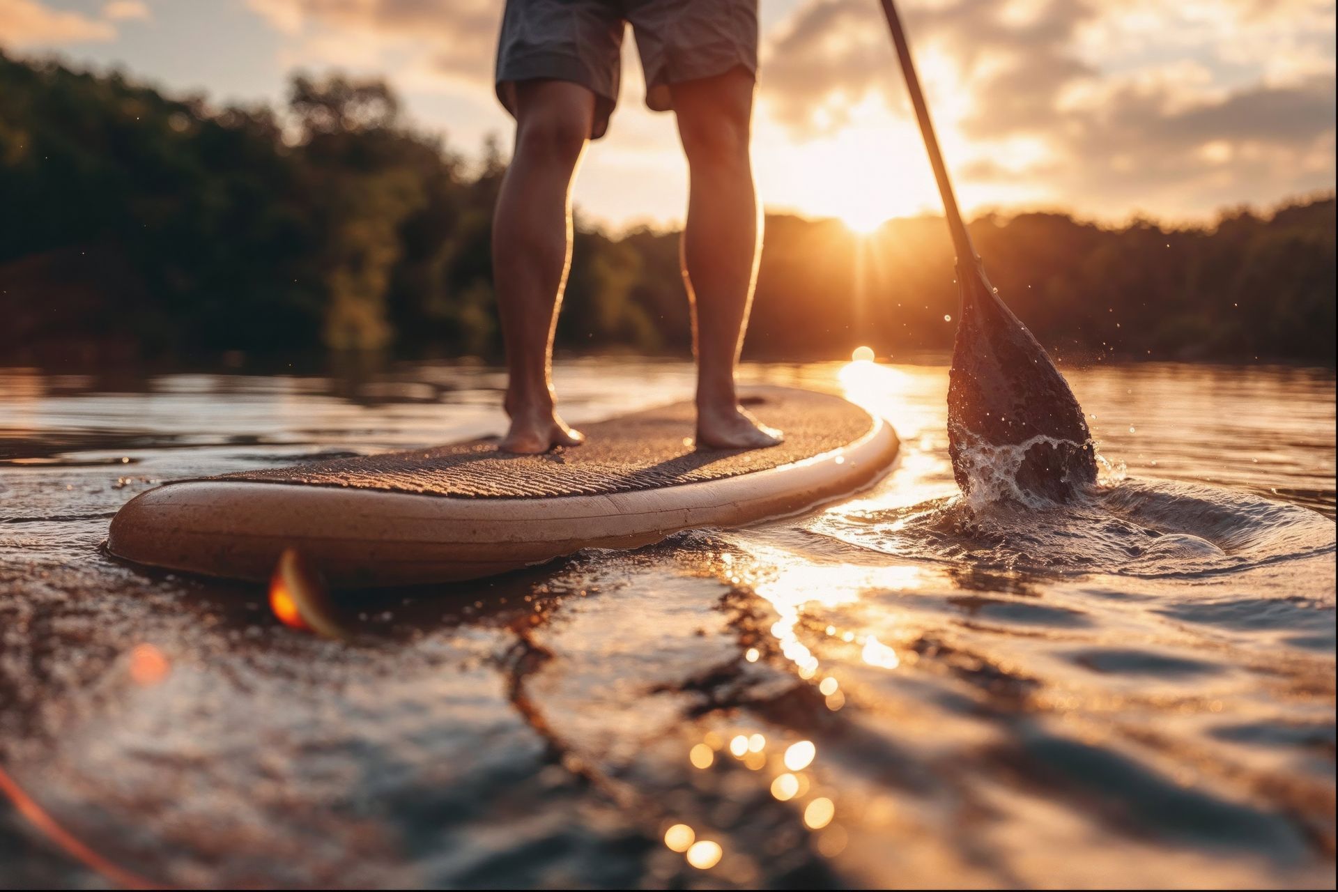 A person is standing on a paddle board in the water.