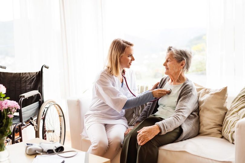 A Nurse is Listening to an Elderly Woman 's Heartbeat With a Stethoscope — Home Nursing Services In Port Macquarie, NSW