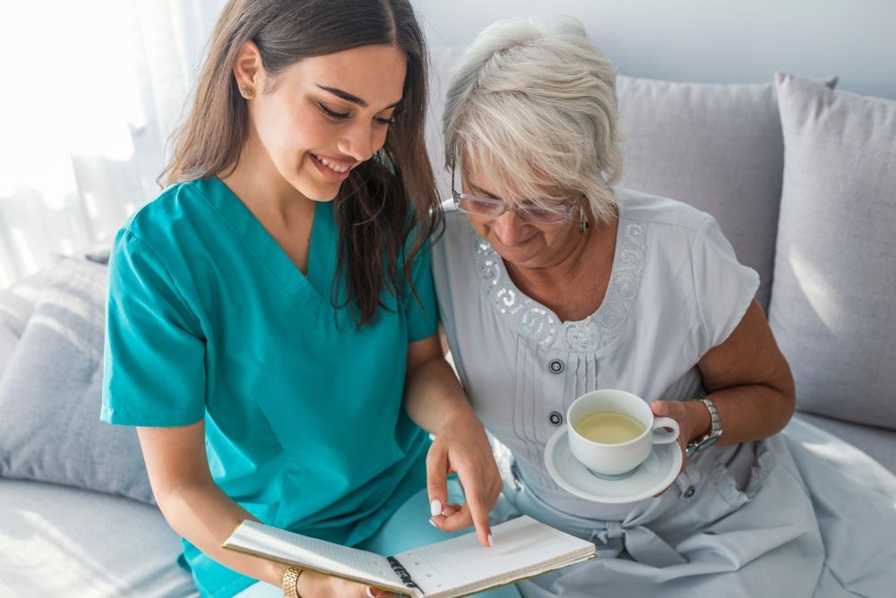 A Nurse Is Reading A Book To An Elderly Woman — Home Nursing Services In Newcastle, NSW